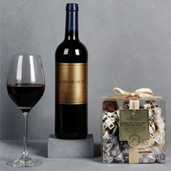 A bottle of bordeaux red wine and italian chocolate assortment