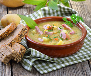 Rich German Pea Soup served with meat sausage and bread