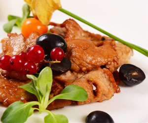 Chicken with red pesto, grapes and wine sauce on watercress